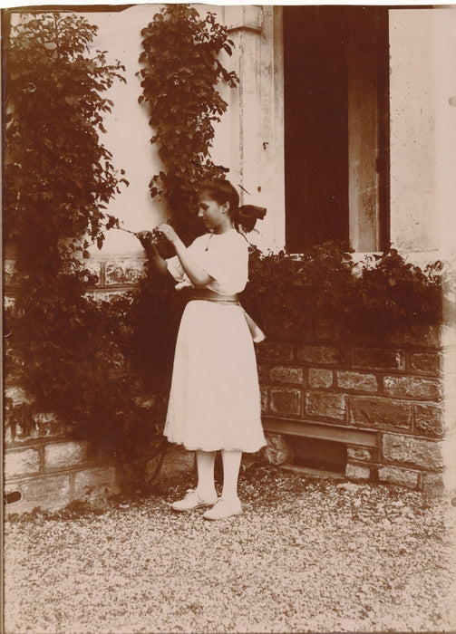 Jeune fille à la robe blanche devant une maison photo photographie v. 1910